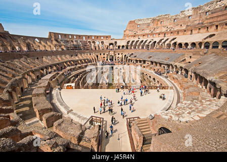 Ein Weitwinkel Innenansicht des Amphitheaters im Inneren des Kolosseums mit Touristen Besucher an einem sonnigen Tag mit blauem Himmel der mittleren Ebene 2 entnommen. Stockfoto