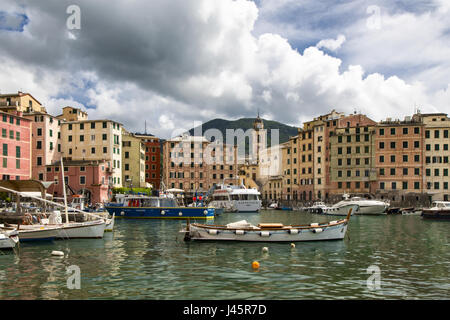 Malerische Aussicht auf die Fischerei Dorf von Camogli an der italienischen Riviera mit kleinen Booten vertäut im Hafen vor bunten Uferpromenade bauen Stockfoto