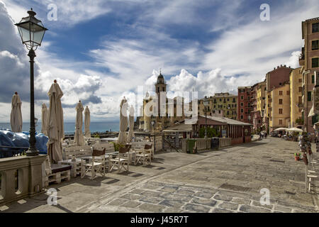 Tischen und Sonnenschirmen an der Camogli Uferpromenade mit Blick aufs Meer an einem bewölkten blauen Himmel Tag in dieser beliebten italienischen Urlaubsort an der Ri Stockfoto