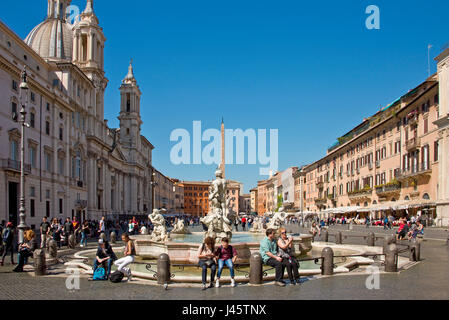 Fontana del Moro oder Moor-Brunnen auf der Piazza Navona (Rom) mit Touristen und Besucher an einem sonnigen Tag mit blauem Himmel. Stockfoto