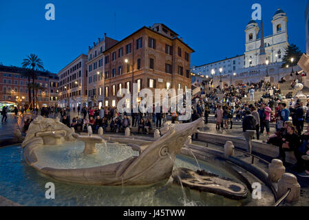 Spanische Treppe in Rom mit Touristen und Besucher, Abend, Nacht mit der Trinità dei Monti Kirche Hintergrund und Brunnen des hässlichen Boot Vordergrunds. Stockfoto