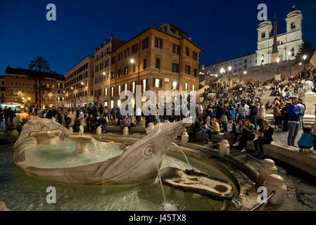 Spanische Treppe in Rom mit Touristen und Besucher, Abend, Nacht mit der Trinità dei Monti Kirche Hintergrund und Brunnen des hässlichen Boot Vordergrunds. Stockfoto