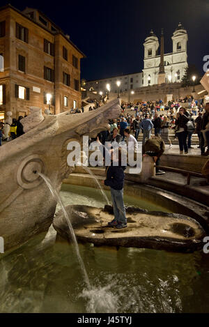 Spanische Treppe in Rom einen Touristen posieren für ein Foto auf dem Brunnen das hässliche Boot-Abend, Nacht mit dem Trinità dei Monti kirchlichen Hintergrund. Stockfoto