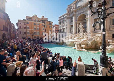 Der Trevi-Brunnen Fontana di Trevi in Rom mit Massen von Touristen und Besucher an einem sonnigen Tag mit blauem Himmel. Stockfoto