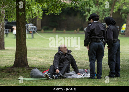 Polizisten-Frage dann bewegen sich auf eine grobe Schläfer in Londons Geraldine Mary Harmsworth Park. VEREINIGTES KÖNIGREICH. Stockfoto