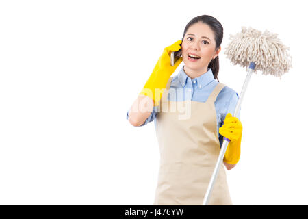 Schöne Hausfrau mit Smartphone-Aufruf für professionelle Haus-Reinigungs-Service freundlich und halten Mop sprechen. isoliert auf weißem Hintergrund. mischen Stockfoto