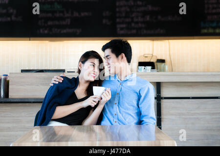 Asiatische schönes junges Paar in einem Café sitzen, Kaffee trinken und genießen das Gespräch. Romantisch zu zweit im Café aus. Liebe und Zärtlichkeit Stockfoto