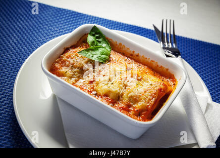 Lasagne in weißer Teller mit grünen Blatt verziert. Stockfoto