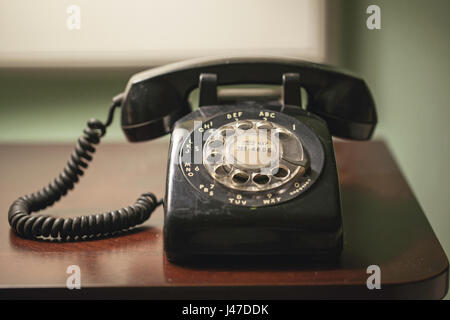 Antik retro Vintage schwarze rotary Wtith aufgewickelt Telefonkabel auf einem Holz-Schreibtisch Stockfoto