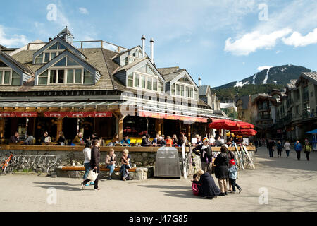 Menschen genießen die Whistler Village in Straßencafés und Restaurants an einem sonnigen Tag im Frühjahr.  Whistler, BC, Kanada Stockfoto