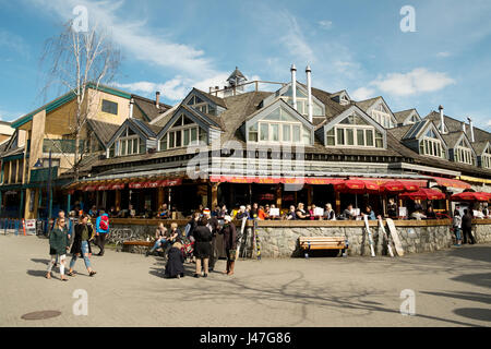 Menschen genießen die Whistler Village in Straßencafés und Restaurants an einem sonnigen Tag im Frühjahr.  Whistler, BC, Kanada Stockfoto