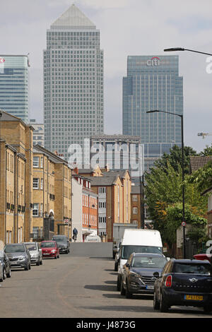 Blick entlang Rotherhithe Straße im Südosten London, einer Wohnstraße mit den Türmen der Canary Wharf im Hintergrund. Radfahrer zeigt in Ferne. Stockfoto