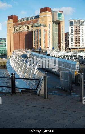 Die Fußgängerzone und Fahrrad Zugang zur Gateshead Millennium Bridge über den Fluss Tyne mit der Baltic Flour Mill Newcastle upon Tyne England UK Stockfoto