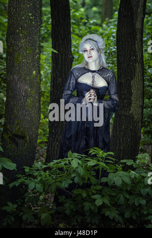 Schöne junge blonde Frau allein im Wald wie ein Gespenst. Stockfoto