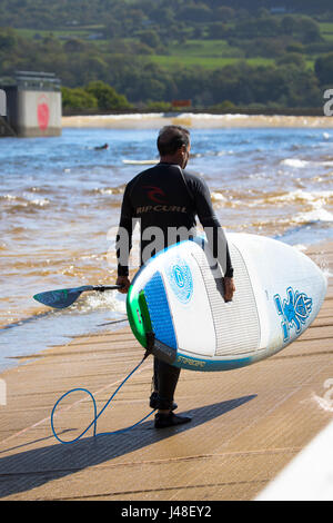 Ein Surfer mit Surfbrett im künstlichen Wellenbad in Conwy Tal surfen Snowdonia Stockfoto