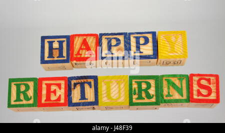 Die Phrase glücklich kehrt angezeigten visuell auf einem weißen Hintergrund mit bunten Holzklötzen Stockfoto