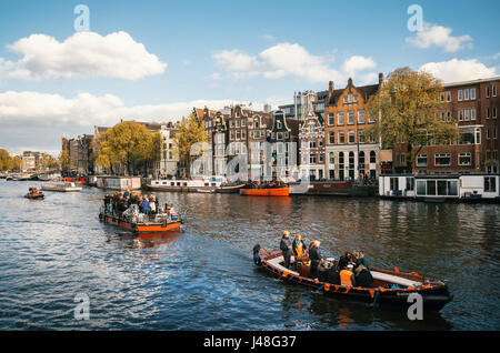 Amsterdam, Niederlande - 25. April 2017: Einheimische und Touristen in orange Kleidung gekleidet fahren auf Booten und bei der Feier des Königs Tag teilnehmen Stockfoto