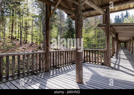 Anzeigen von Holzsteg für Tierbeobachtungen, Bayern, Deutschland. Terrasse für Tiere in den Wäldern zu beobachten. Holzbrücke mit einem Dach in den Wald. Stockfoto