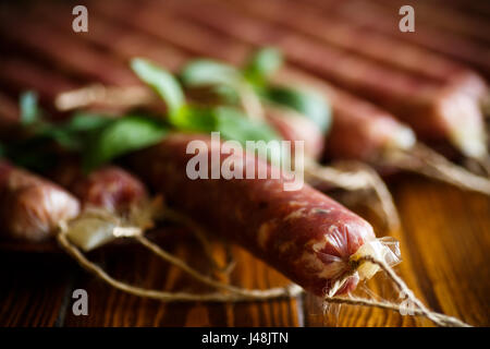 Rohe Bio Hausmacher Wurst, hergestellt aus natürlichen Fleisch auf einem Holztisch Stockfoto