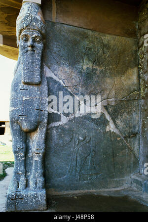 Nimrud, Irak: ein Mensch-unter der Leitung geflügelten Stier mit damit verbundenen Genie bewachten Eingang (Tor D) in den Thronsaal von Ashurnasirpal II C9thBC NW Palast. Stockfoto