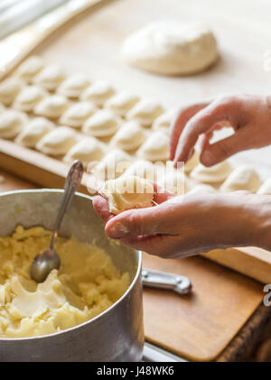 Frau Wareniki oder Knödel Pierogi an Holz Bord vorbereiten, kochen. Koch bereitet traditionellen ukrainische Küche. Mutter macht leckeres Gericht für Stockfoto