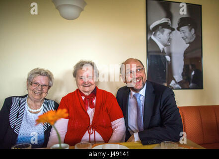 Pasewalk, Deutschland. 10. Mai 2017. SPD-Kandidat für Kanzler und Partei Martin Schulz (r) Vorsitzender besucht die "Cura Seniorencentrum" Kindergarten nach Hause und und spricht mit Waltraud Sterlinski (l) Und Siegrid Peters (c) in Pasewalk, Deutschland, 10. Mai 2017. (Foto durch ein Fenster). Schulz möchte über die Entwicklung im Nordosten bei Besuchen in Pasewalk und Rostock erlernen. Foto: Jens Büttner/Dpa-Zentralbild/Dpa/Alamy Live News Stockfoto