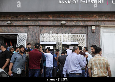 (170510)--GAZA, 10. Mai 2017 (Xinhua)--Palästinenser von der palästinensischen Autonomiebehörde (PNA) warten eingesetzt, um ihre Gehälter von einem Geldautomaten vor einer Bank in Gaza-Stadt, am 10. Mai 2017 erhalten. Die Gehälter der palästinensische Beamte und ehemalige Sicherheitsbeauftragte im Gaza-Streifen wurden reduziert um etwa 30 Prozent für den zweiten Monat in Folge da Regierung der palästinensischen Autonomiebehörde (PNA) die Entscheidung in Ramallah am 4. April ausgestellt. (Xinhua/Wissam Nassar) Stockfoto