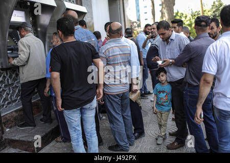 (170510)--GAZA, 10. Mai 2017 (Xinhua)--Palästinenser von der palästinensischen Autonomiebehörde (PNA) warten eingesetzt, um ihre Gehälter von einem Geldautomaten vor einer Bank in Gaza-Stadt, am 10. Mai 2017 erhalten. Die Gehälter der palästinensische Beamte und ehemalige Sicherheitsbeauftragte im Gaza-Streifen wurden reduziert um etwa 30 Prozent für den zweiten Monat in Folge da Regierung der palästinensischen Autonomiebehörde (PNA) die Entscheidung in Ramallah am 4. April ausgestellt. (Xinhua/Wissam Nassar) Stockfoto