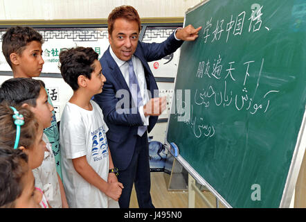 (170511)--YIWU, 11. Mai 2017 (Xinhua)--iranischer Geschäftsmann Hamid Dehgh (1. R) lehrt Chinesisch für Kinder aus Nahost Nationen in einem Servicecenter für Ausländer in Yiwu-Stadt in der ostchinesischen Provinz Zhejiang, 9. Mai 2017. Hamid, 52, begab sich Yiwu im Jahr 2003 auf ein Unternehmen auf die Einfuhr von iranischen Seidentücher zu führen und ein ausländische Handelsunternehmen wurde von Hamid und seine chinesische Frau 2007 gegründet, mit geschäftlichen Verbindungen erweitert nun zu vielen Städten in Asien, Europa und Nordamerika. Hamid hat in der Innenstadt von Yiwu niedergelassen. Er fließend Chinesisch sprechen konnte und schickte seine Tochter zum Studium an einer loca Stockfoto