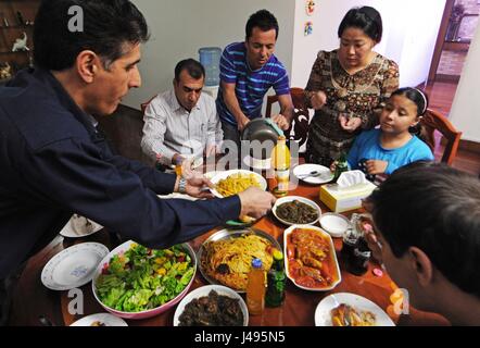 (170511)--YIWU, 11. Mai 2017 (Xinhua)--iranischer Geschäftsmann Hamid Dehgh und seine Familie ihre iranischen Verwandten und Freunde zu Hause in Yiwu-Stadt in der ostchinesischen Provinz Zhejiang, 3. April 2013 zu behandeln. Hamid, 52, begab sich Yiwu im Jahr 2003 auf ein Unternehmen auf die Einfuhr von iranischen Seidentücher zu führen und ein ausländische Handelsunternehmen wurde von Hamid und seine chinesische Frau 2007 gegründet, mit geschäftlichen Verbindungen erweitert nun zu vielen Städten in Asien, Europa und Nordamerika. Hamid hat in der Innenstadt von Yiwu niedergelassen. Er fließend Chinesisch sprechen konnte und schickte seine Tochter zum Studium an einer lokalen chinesischen Mittelschule. Yiwu Stockfoto