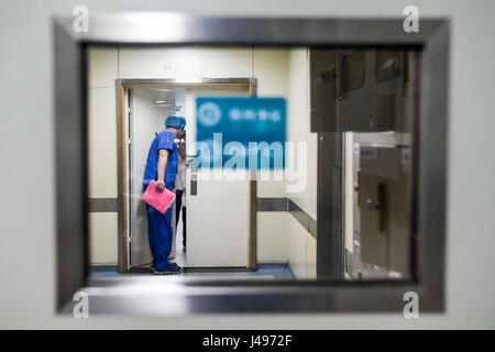 Zhengzhou, China Henan Provinz. 9. Mai 2017. Krankenschwester Liu Xiangda Gespräche mit Familienangehörigen des Patienten in der Intensivstation (ICU) von Zhengzhou Central Hospital in Zhengzhou, Hauptstadt der Provinz Zentral-China Henan, 9. Mai 2017. Liu, 25, ist eine der über 70 Pfleger im Krankenhaus. Die Anzahl der Krankenschwestern in China erreicht 3,5 Millionen zum Jahresende 2016 nach den jüngsten Statistiken vor Krankenschwestern Welttag, die am 12. Mai fällt. Bildnachweis: Li Bo/Xinhua/Alamy Live-Nachrichten Stockfoto