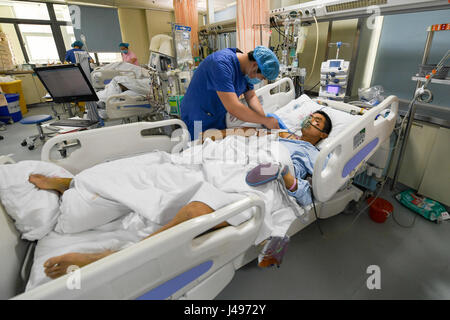 Zhengzhou, China Henan Provinz. 9. Mai 2017. Krankenschwester Liu Xiangda prüft ein Patient auf der Intensivstation (ICU) von Zhengzhou Central Hospital in Zhengzhou, Hauptstadt der Provinz Zentral-China Henan, 9. Mai 2017. Liu, 25, ist eine der über 70 Pfleger im Krankenhaus. Die Anzahl der Krankenschwestern in China erreicht 3,5 Millionen zum Jahresende 2016 nach den jüngsten Statistiken vor Krankenschwestern Welttag, die am 12. Mai fällt. Bildnachweis: Li Bo/Xinhua/Alamy Live-Nachrichten Stockfoto