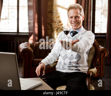 Porträt der schönen Psychiater Mann lächelnd und Blick in die Kamera. Psychiater Mann halten und Vertretung Sanduhr in der hand während des Wartens auf pat Stockfoto