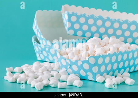 Haufen von kleinen farbigen geschwollene Marshmallows auf türkisblauem Hintergrund isoliert hautnah Stockfoto