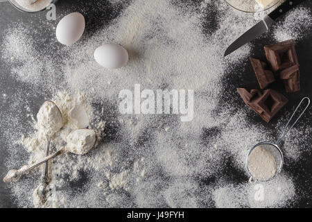 Backen Kuchen Zutaten. Schüssel, Mehl, Eiern, Quirle an schwarze Tafel von oben. Kochen Kurs Plakat Hintergrund Stockfoto