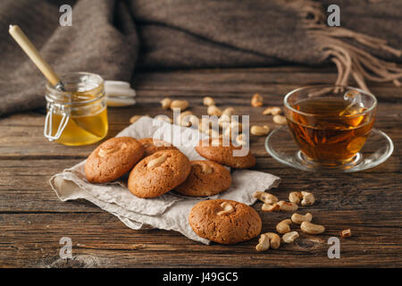 Hausgemachte Haferkekse mit einer Tasse Tee auf alten hölzernen Hintergrund Stockfoto