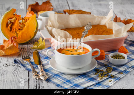 Kürbissuppe-Püree mit Gewürzen auf einem Holztisch Stockfoto