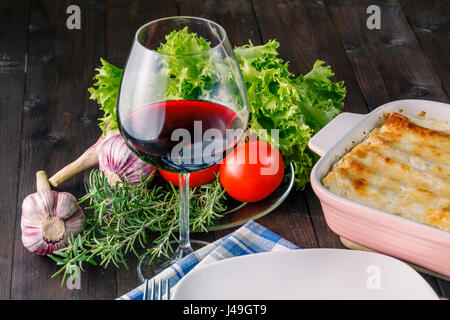 Frisch zubereitete Lasagne mit Zutaten auf Tisch Stockfoto