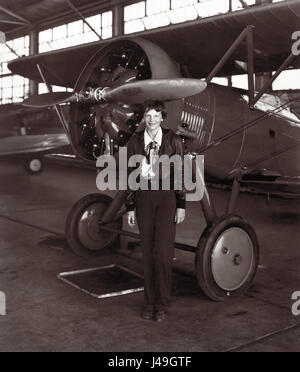 Amelia Earhart, die erste Frau, machen einen Alleinflug über den Atlantik, steht man vor einem Doppeldecker am 30. Juli 1936, fast ein Jahr, bevor sie über dem Pazifischen Ozean in Anfang Juli 1937 verschwand. Stockfoto