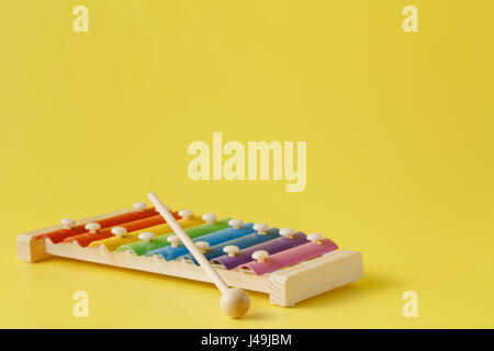 Bunte Baby Xylophon mit Stick auf gelb Stockfoto