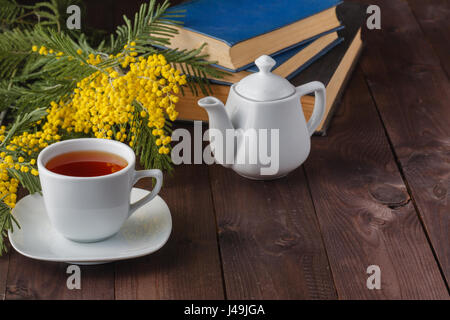 Frühling des Teetrinkens mit Büchern und gelbe Blumen Stockfoto