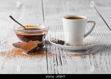 Tasse Kaffee und Süßigkeiten auf weißem Hintergrund Stockfoto