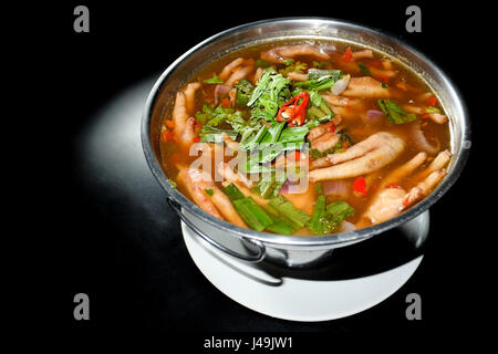 Würzige Suppe Chicken Foot in heiße Schüssel und schwarzem Hintergrund Stockfoto