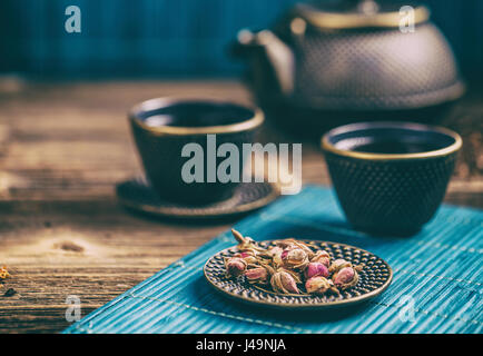 Trockener rose Tee Knospen auf Gusseisen Untertasse Stockfoto