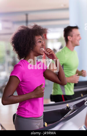 junge Leute Exercisinng Cardio am Laufband läuft Maschine im modernen Fitnessraum Stockfoto