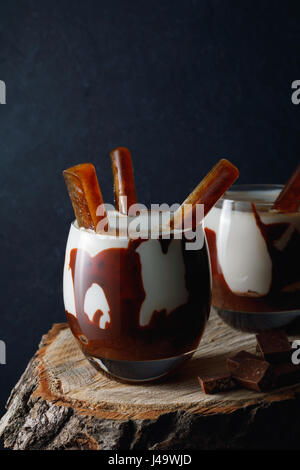 Süße Cocktails in Gläsern mit Schokolade, Vanille Eis Creme und Eiswürfeln Kaffee auf rustikalen hölzernen Hintergrund. Stockfoto