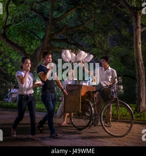 HANOI, VIETNAM - ca. SEPTEMBER 2014: Passanten am Hoan-Kiem-See in der Nacht in Hanoi, Vietnam. Stockfoto