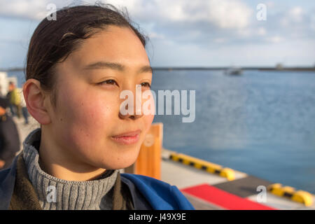 Sado Island, Japan - April 1th, 2017: portrait eines japanischen junge Frau weg an sado Insel Port suchen. Stockfoto