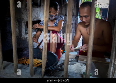 VAN HA, VIETNAM - ca. SEPTEMBER 2014: Junge vietnamesische Coupé kocht im Lang Gom Tho Ha Village. Das Dorf gehört zur Gemeinde Van Ha, es ist Stockfoto