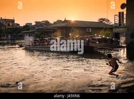 VAN HA, VIETNAM - ca. SEPTEMBER 2014: Junge springen im Fluss Cau nachmittags um die Lang Gom Tho Ha Dorf. Das Dorf gehört zu den Van-H Stockfoto